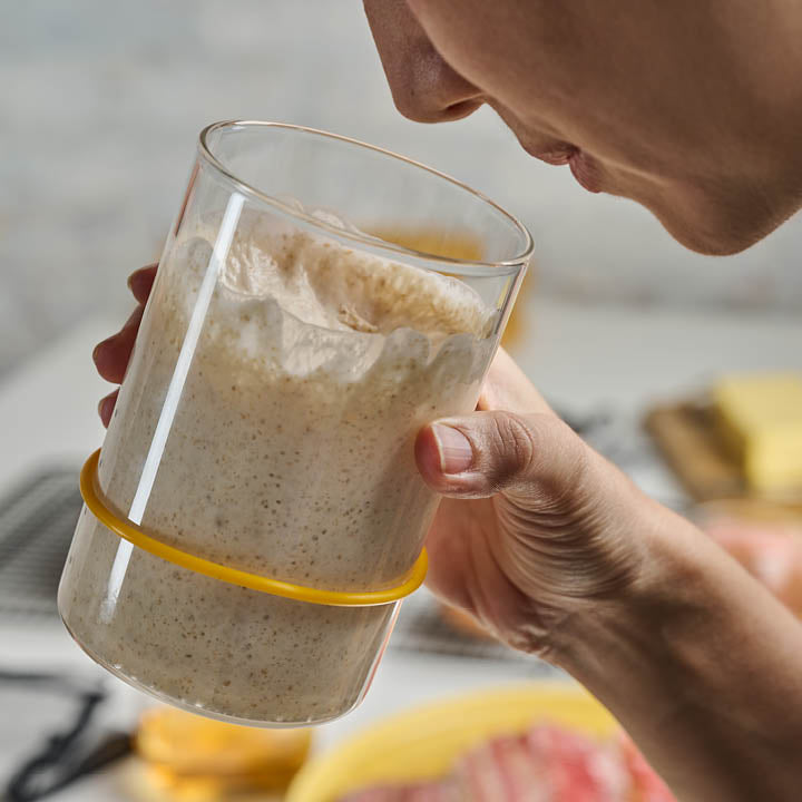 Person smelling active sourdough starter in Sourhouse glass sourdough starter jar